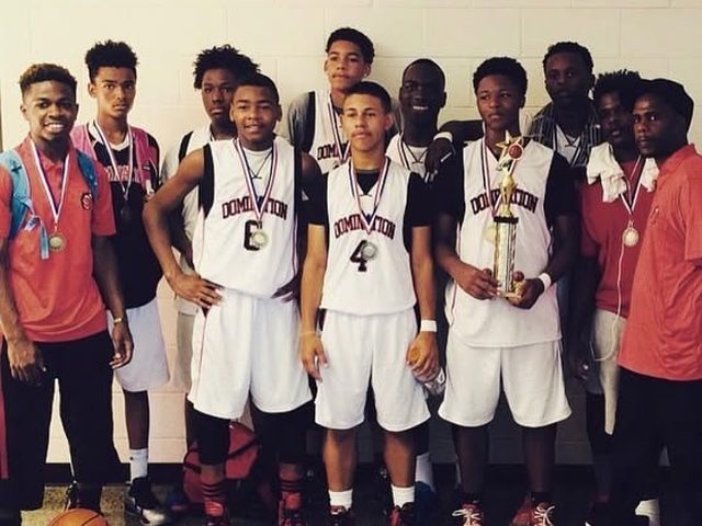 Domination players in white uniforms with medals and a trophy