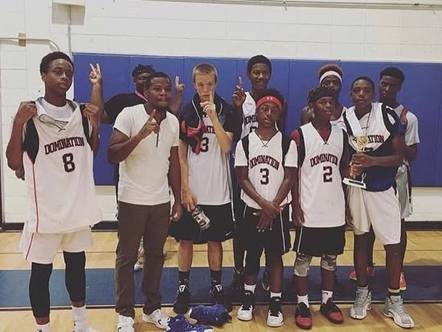 Domination players holding up number-one fingers with a trophy