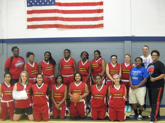 Domination girls team with coaches under an American flag
